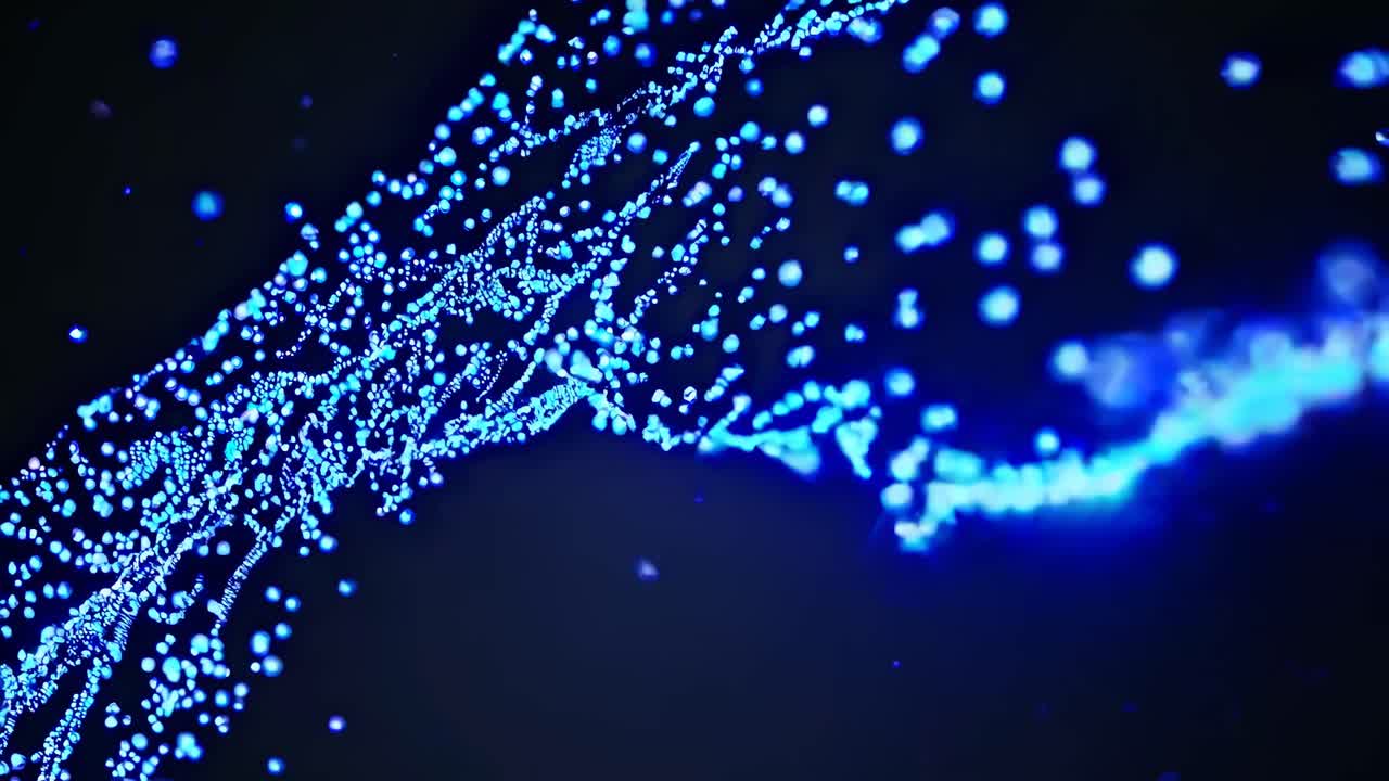 Dynamic video of glowing blue particles forming a wave-like pattern, captured from a side angle