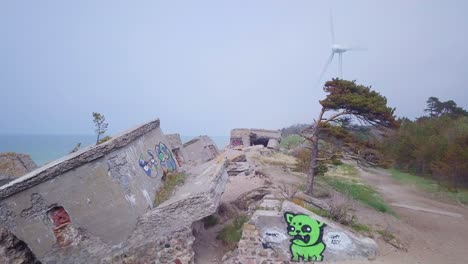 aerial view of abandoned seaside fortification buildings at karosta northern forts on the beach of baltic sea in liepaja, latvia, calm sea on a sunny day, wide angle drone shot moving forward