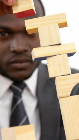 businessman playing with building blocks