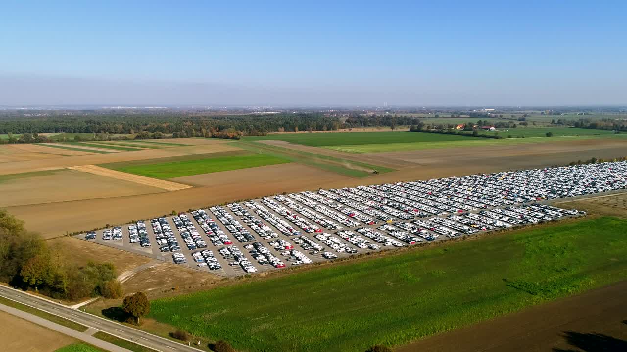 Aerial footage of finished cars ready to be shipped on huge distribution center
