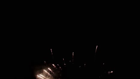 hermosos y coloridos fuegos artificiales reales continúan la celebración en la víspera de año nuevo con un desenfoque abstracto de brillo dorado con luces bokeh en el cielo nocturno