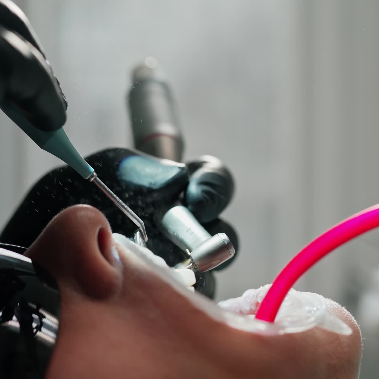 Patient in black safety glasses during tooth treatment. Stomatologist use dental instruments at treating teeth in dentist's office. Close-up.