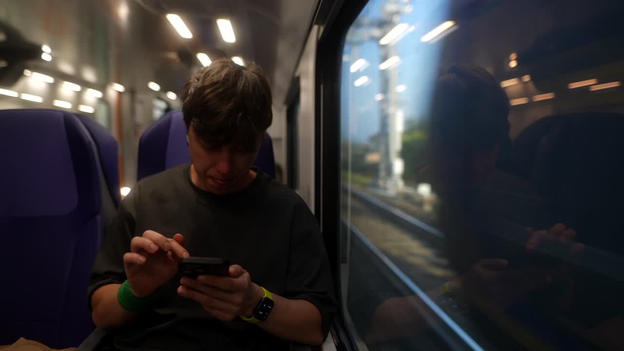 기차에서 스마트폰을 사용하는 남자