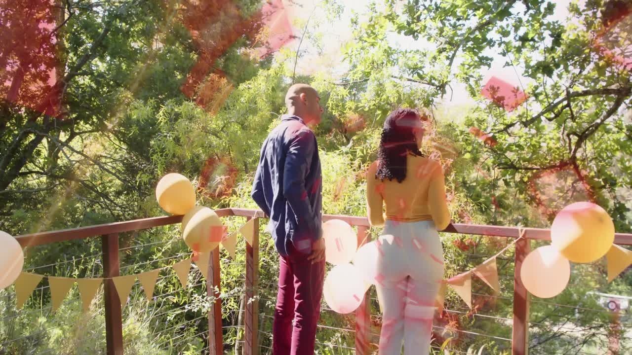 Pair planning party walking onto deck woman pointing and causing pins marking trees and balloons