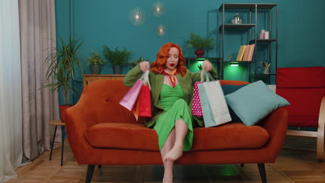 feliz mujer pelirroja adicta a las compras consumidor regresó a casa después de la venta de compras en línea con bolsas en casa