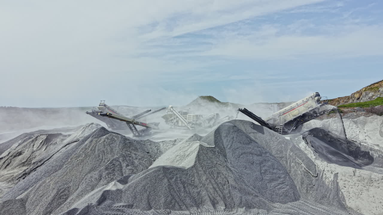 Granite quarry operation shows equipment working on stone extraction and processing in a large outdoor site during the daytime