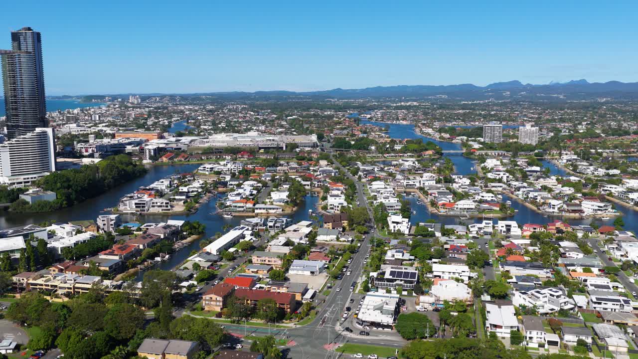 Aerial footage showcasing Gold Coast's urban landscape with high-rise buildings, waterways, and clear skies, captured in bright daylight