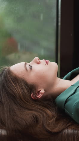 woman business owner finds moment of tranquility. rain outside serves as cleansing force washing away mental fatigue that accumulated throughout day