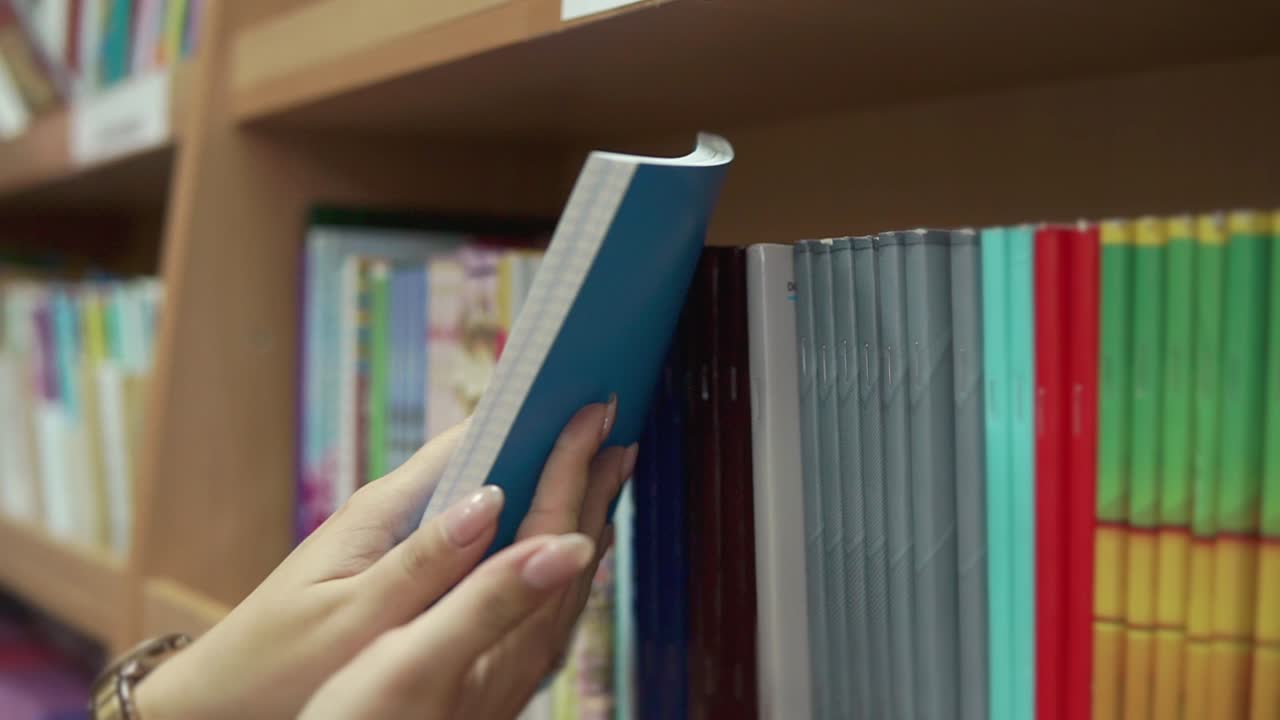 persona que busca libros en una estantería de la biblioteca