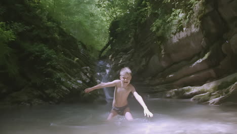 boy playing in a mountain stream