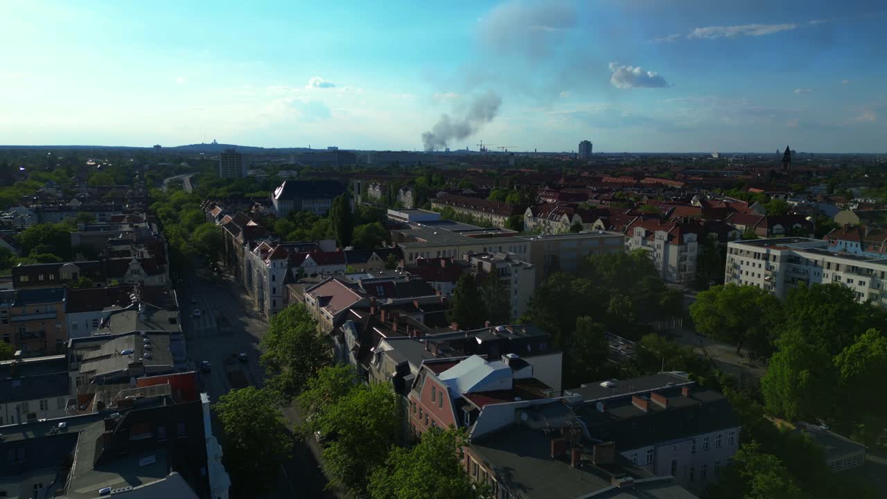 big black smoke rising over Berlin, Germany, on sunny day with blue sky and some clouds. Unique aerial view flight descending drone