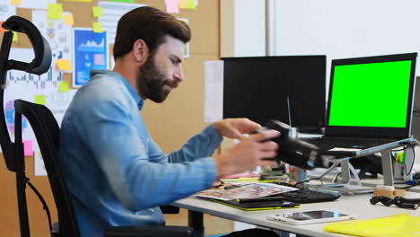 diseñador gráfico masculino mirando fotos en la cámara