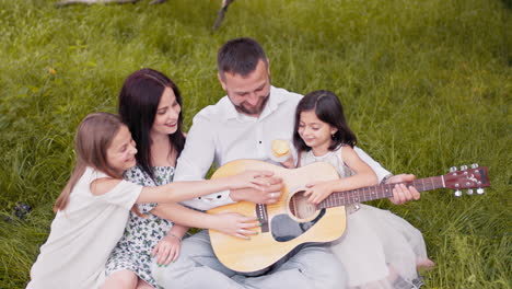 familia tocando la guitarra al aire libre