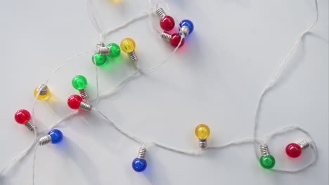 viewed from above, christmas led lights in blue, red, yellow, and green are displayed on a white surface