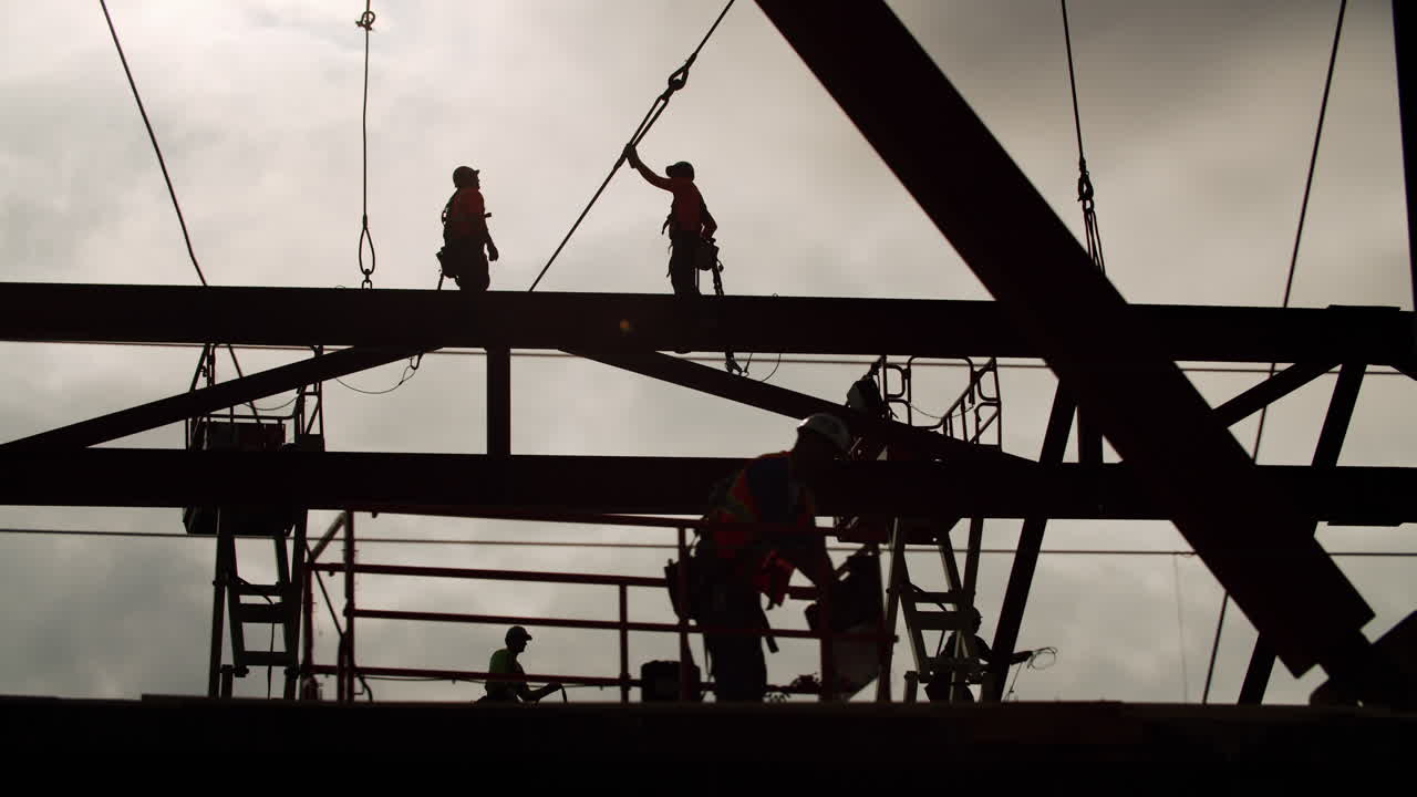 Silhouetted Construction Workers on a Steel Structure