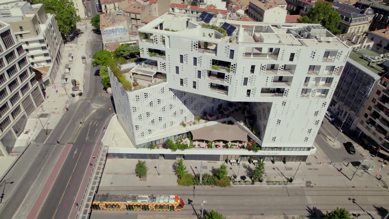 un tranvía colorido conduciendo frente a un hermoso edificio de apartamentos