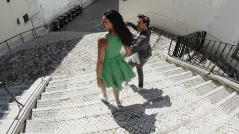 young couple walking down stairs in street.