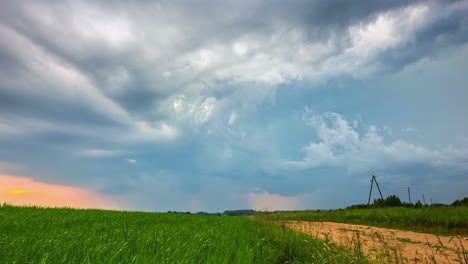 Time-lapse-shot-of-fast-clouds-flying-over-agricultural-field-and-darken-sky,4K---Spectacular-formation-of-dark-clouds-overcast-in-nature