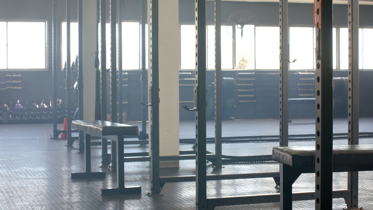 Empty gym with weightlifting equipment and benches
