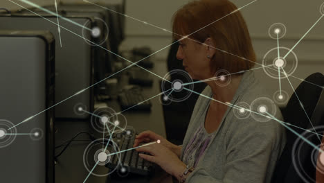animación de la red de conexiones sobre mujer mayor caucásica usando computadora en la oficina