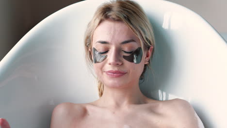 mujer disfrutando de un día de spa en un baño con máscaras para los ojos