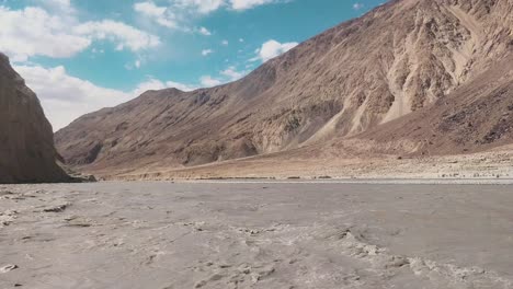 the-mind-calming-video-of-flow-of-shyok-river-in-between-two-mountains-and-beautiful-blue-sky-in-the-ladakh-region