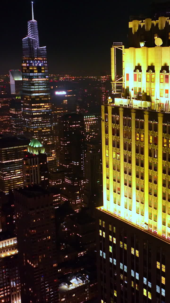 Amazing beautifully-lit top of a skyscraper in New York. Startling cityscape of metropolis at night. Top view. Vertical video