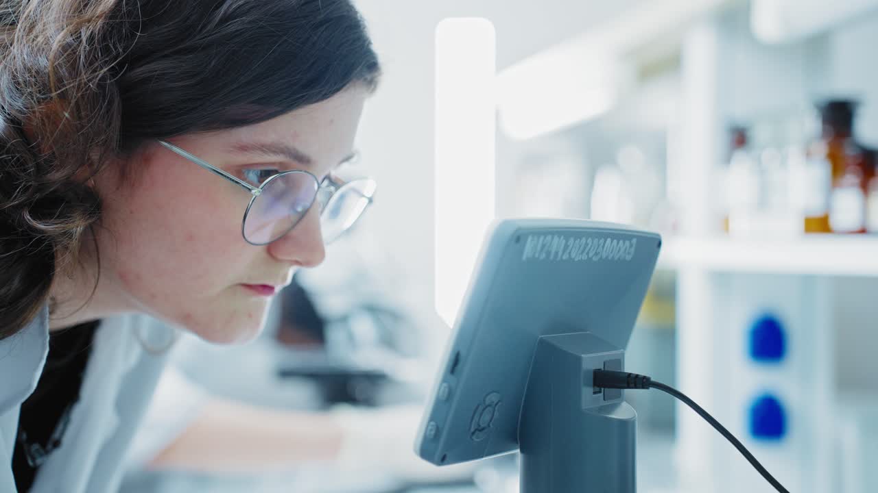 Teenage Girl in Lab Looking at Microscope Screen