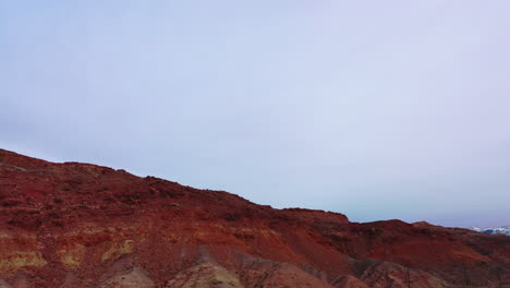 Overtake-shot-of-orange-and-arid-mountains---aerial-view