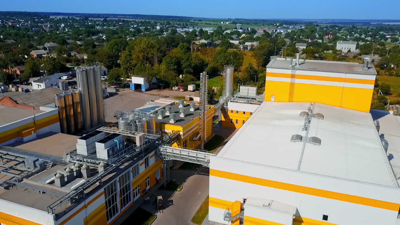 Industrial plant territory with few lorries nearby. Beautiful countryside area with lots of greenery at backdrop. Top view.