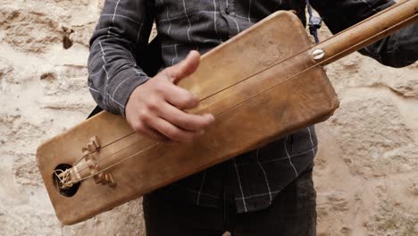 un hombre marroquí está tocando un guembri tradicional marroquí en essaouira, marruecos.