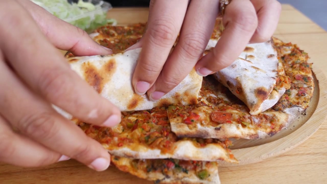 Preparing and Eating Traditional Turkish Lahmacun with Fresh Lettuce