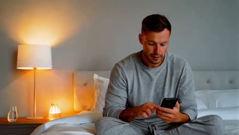 hombre usando el teléfono en la cama por la noche