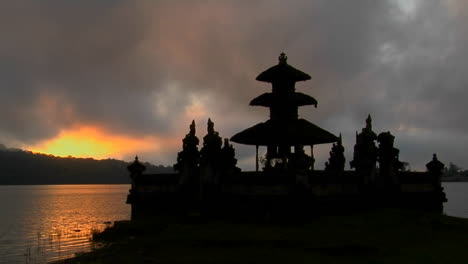 a balinese temple overlooks reflections in a lake