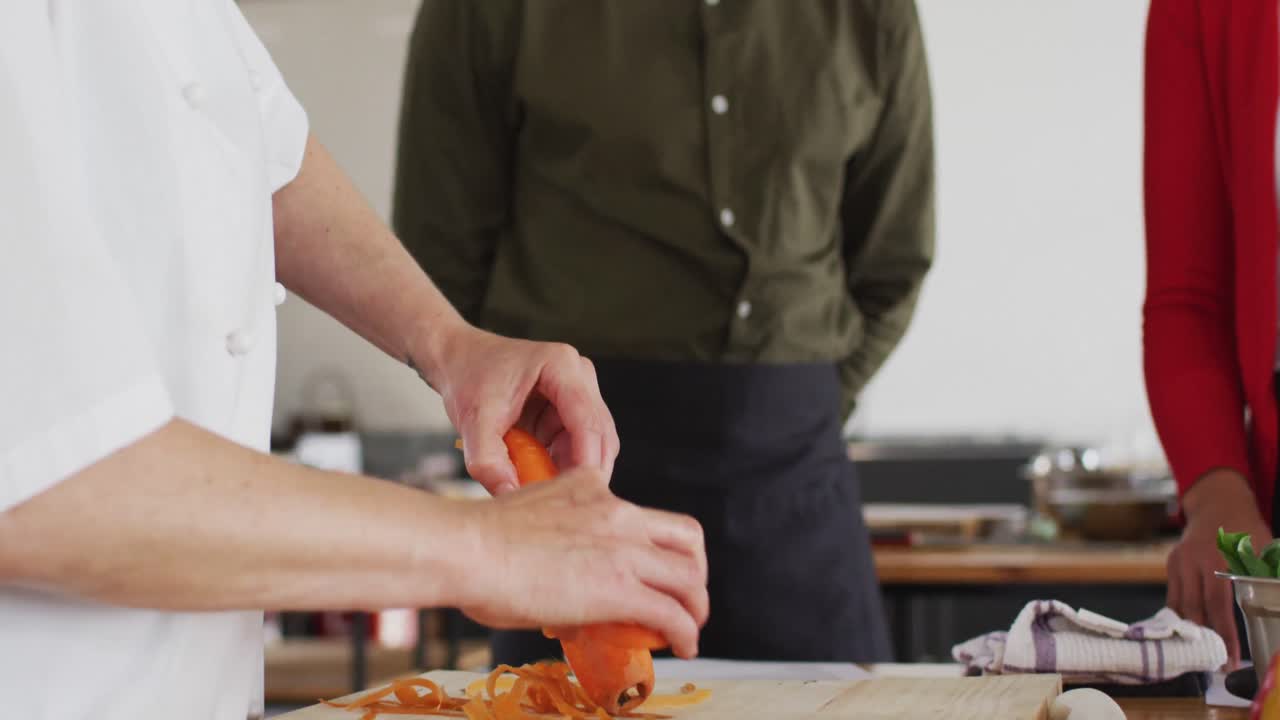 백인 여성 요리사 는 얼굴 마스크 를 쓰고 다양한 집단 을 가르치고 있다