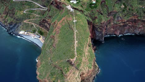 Aerial-view-descending-to-Ponta-du-Garajau-green-island-coastline,-Madeira,-Portugal