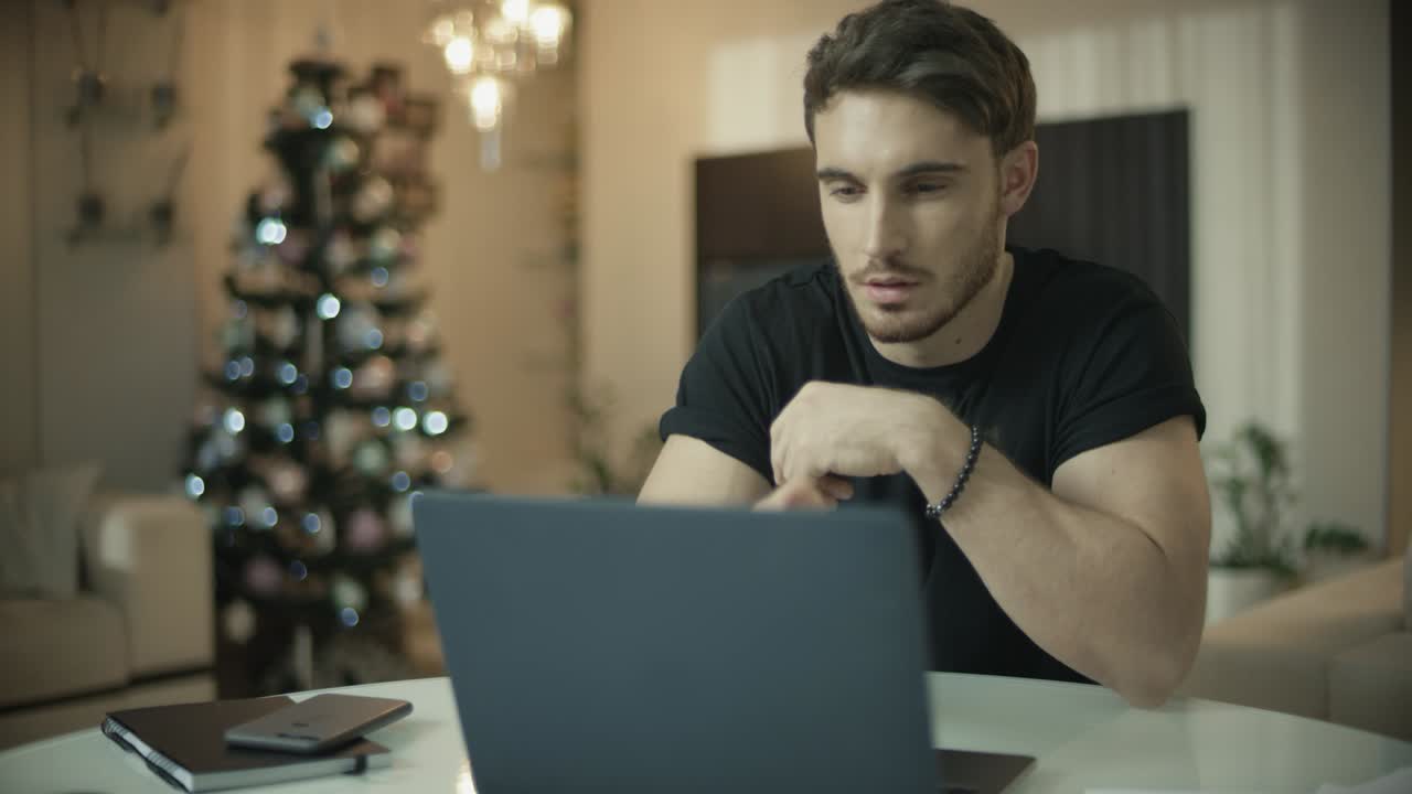 Uomo che usa il laptop vicino all'albero di Natale. Uomo d'affari casual che fa acquisti online.