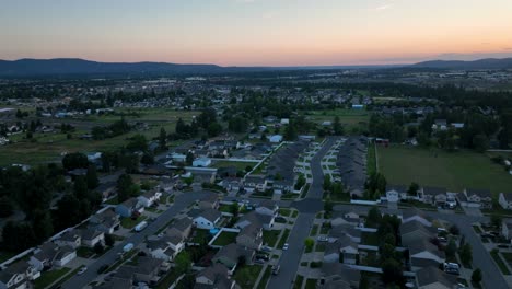 Aerial-shot-above-middle-class-neighborhood-as-the-sun-begins-to-rise-off-in-the-distance
