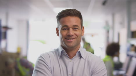 retrato de un gerente masculino sonriente en un almacén de distribución de logística ocupado