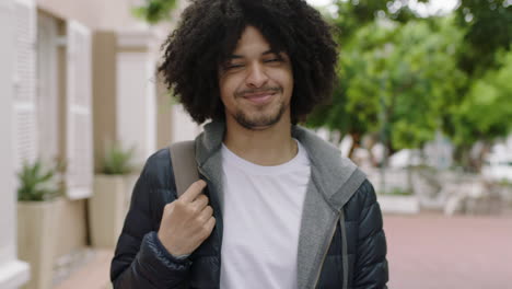 retrato de joven estudiante de raza mixta hombre sonriendo alegremente mirando a la cámara disfrutando de un estilo de vida independiente en la ciudad urbana peinado afro de moda