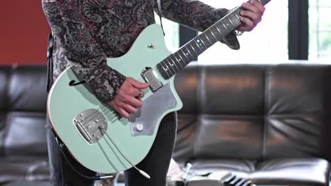 a man is playing guitar in his studio