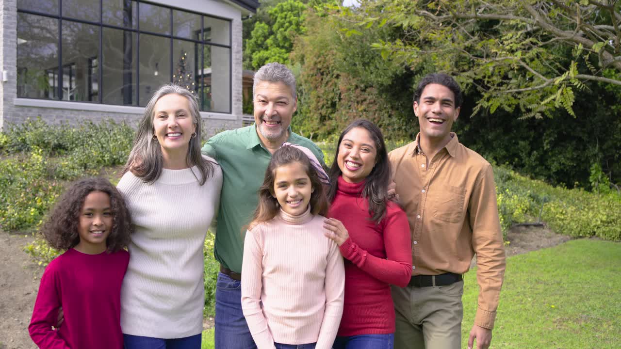Opening shot spurring diverse family standing under tree laughing as camera zooming in portrait