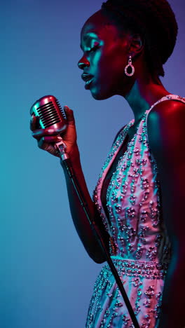singer performing with vintage microphone under colorful lights
