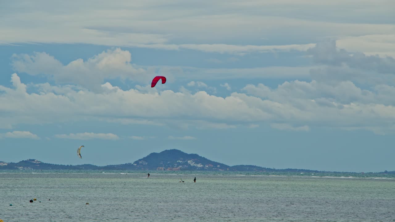 Kiteboarding and fishing boats on the sea