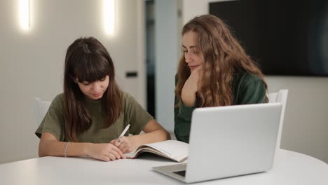 teen student girl has individual lesson from young woman teacher with laptop