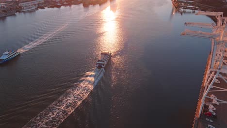 ferry in the port of oakland estuary going to san francisco - sunset aerial