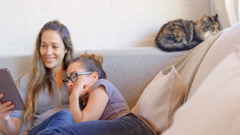 lesbian couple using digital tablet in living room 4k