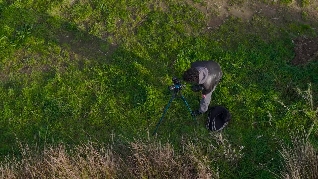 자연 사진작가 가 삼각대 에 있는 카메라 를 사용 하여 촬영 하기 위한 전망 을 찾고 있다