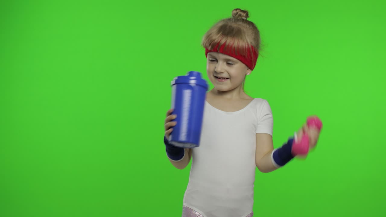 niña con ropa deportiva haciendo ejercicios de fitness con pesas y agua potable. niño atlético