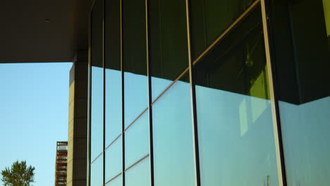 primer plano de la esquina de un edificio moderno con vidrio reflectante y sombras que proyectan la luz solar